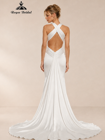 Back view of an ivory mermaid wedding dress with crisscross straps, an open back and train.