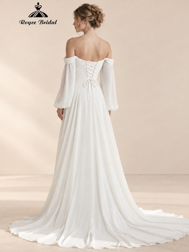 Back view of an ivory off-the-shoulder A-line wedding dress with long sleeves, a lace-up back and train.