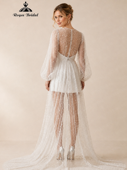 Back view of an ivory beaded mini wedding dress with sheer long sleeves, open back, and flowing train.