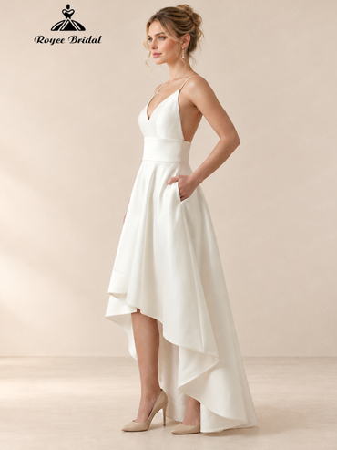 Side view of an ivory satin high-low wedding dress with spaghetti straps, open back, and side pockets.